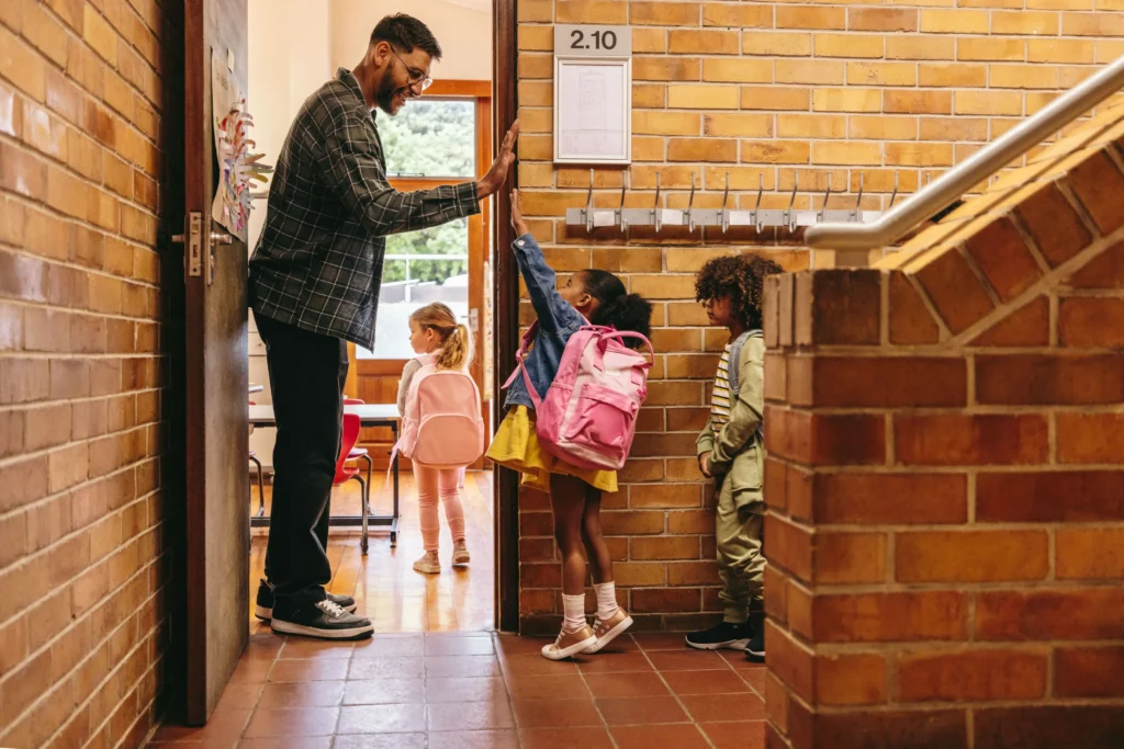 Teacher greeting kindergarten students on the first day of school