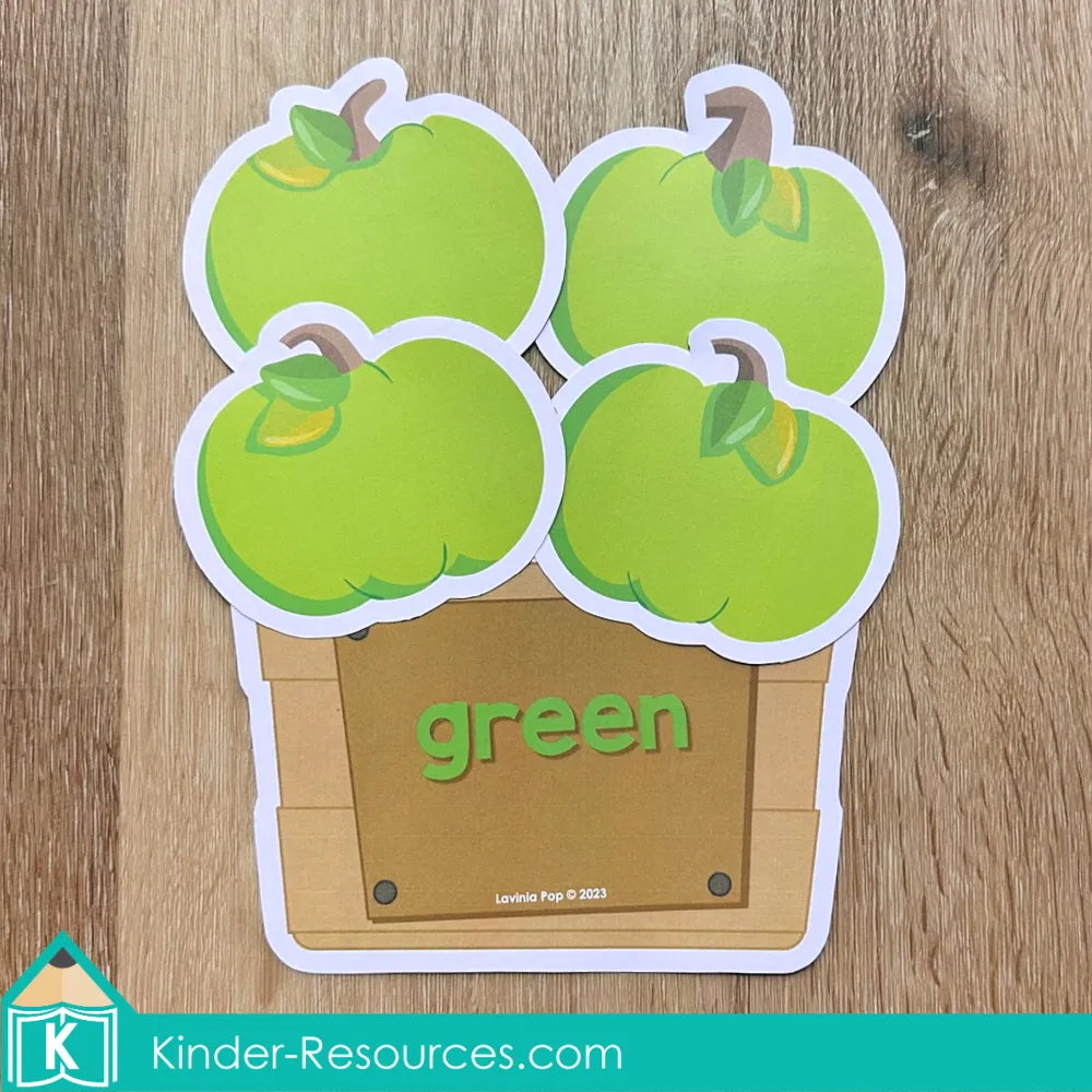 Pumpkin color sorting crate activity with green pumpkins matched to the crate labeled green.