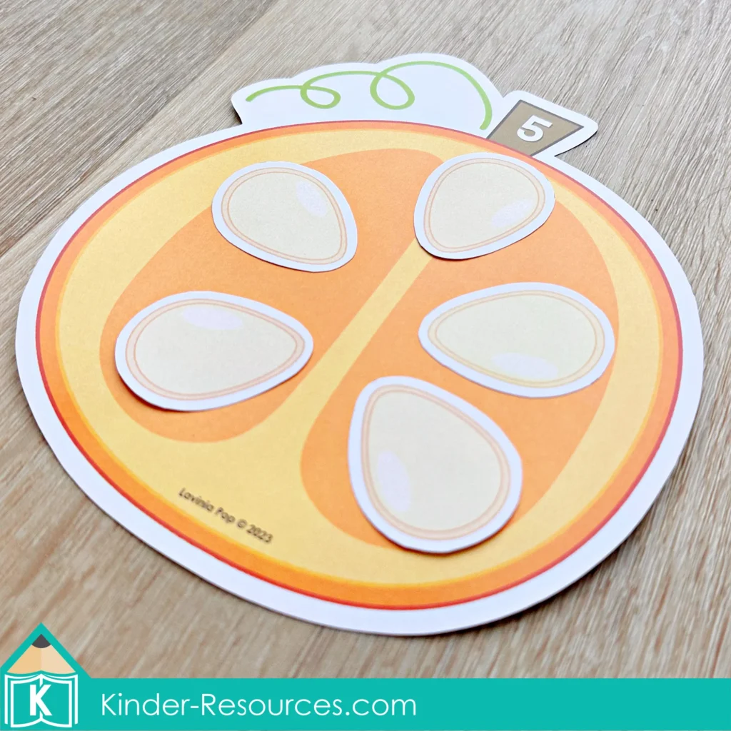 Pumpkin counting mat showing the number five with pumpkin seeds for preschool number recognition.