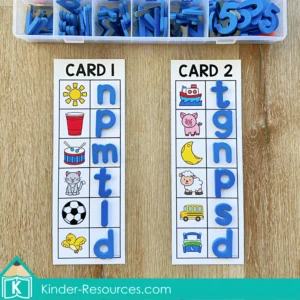 Children matching ending sounds using blue lowercase letter tiles and picture cards in a Kindergarten phonics center activity