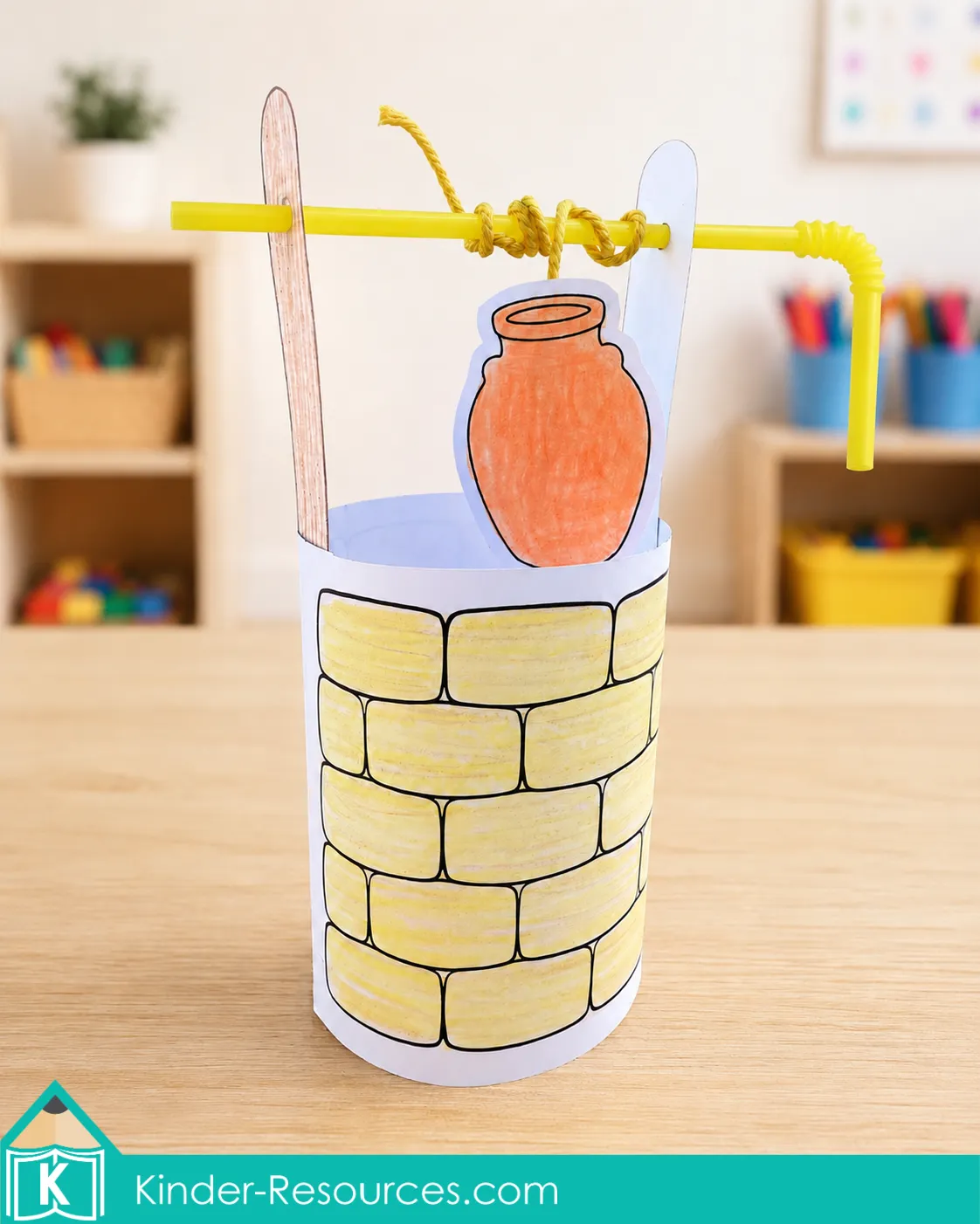 Isaac and Rebekah Interactive Well Craft Completed preschool Bible well craft made with a paper stone wrapper, wooden supports, bendy straw, string, and a movable clay water jar.