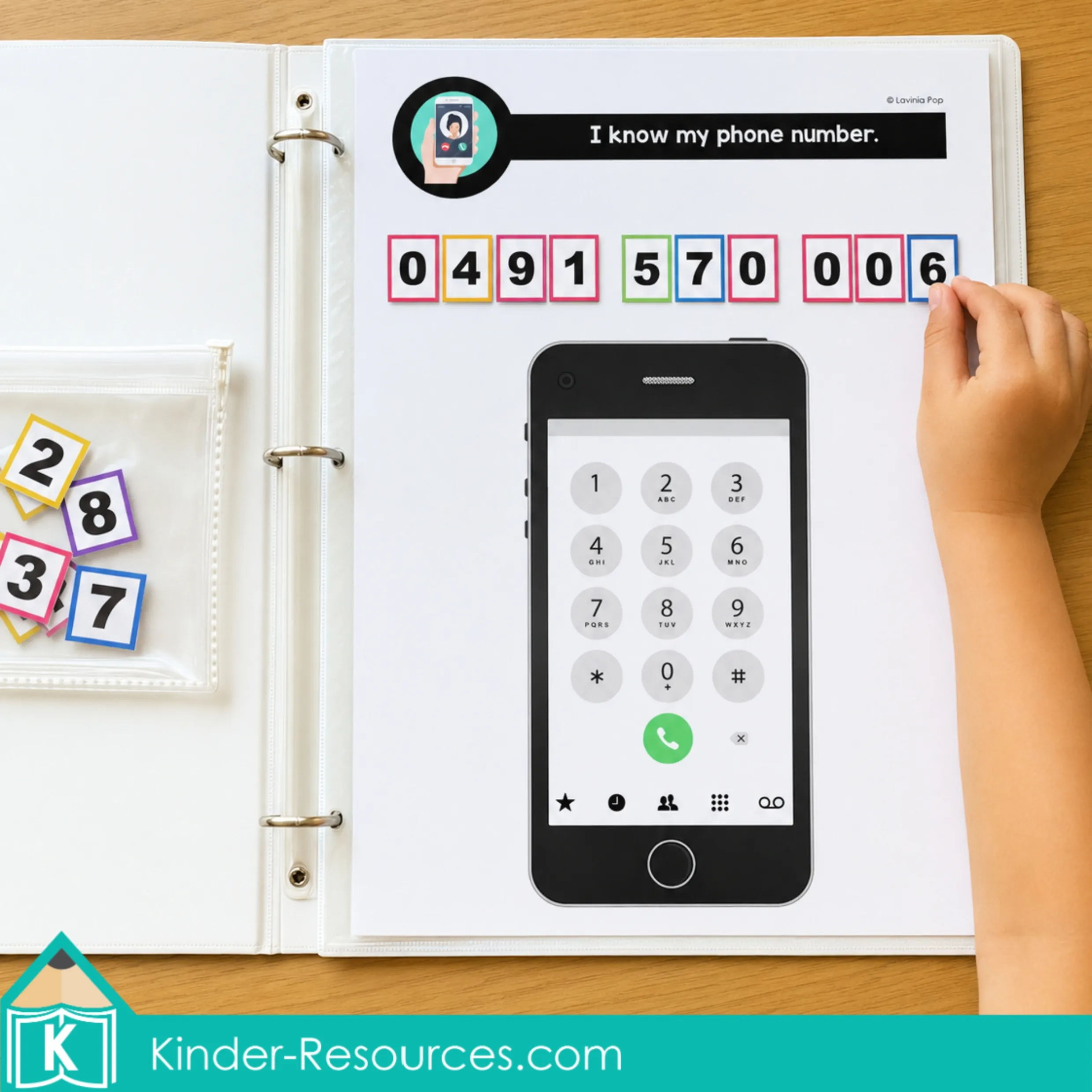 Child places the final colorful numeral tile on a laminated phone number practice mat inside a binder with a realistic phone keypad.