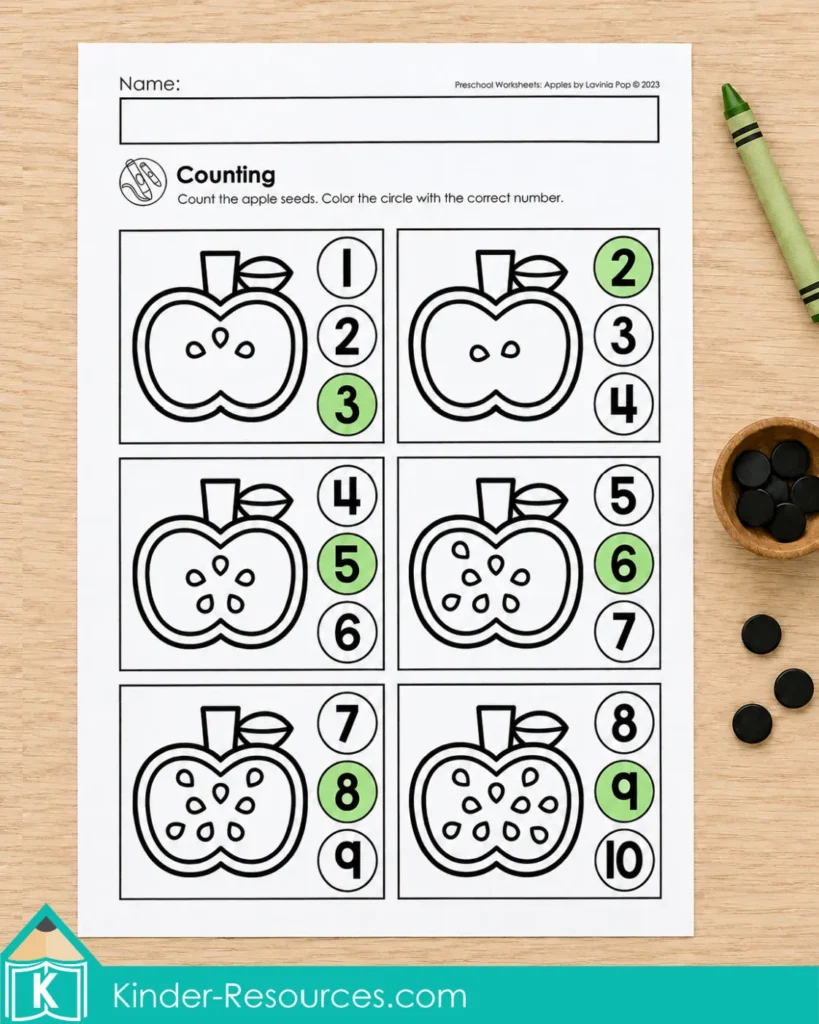 Apple counting worksheet with groups of apple seeds, number choices, a green crayon, and black counters.