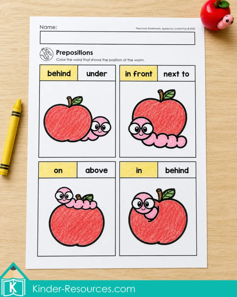 Apple positional words worksheet showing a worm behind, under, in front of, next to, on, above, and inside an apple.