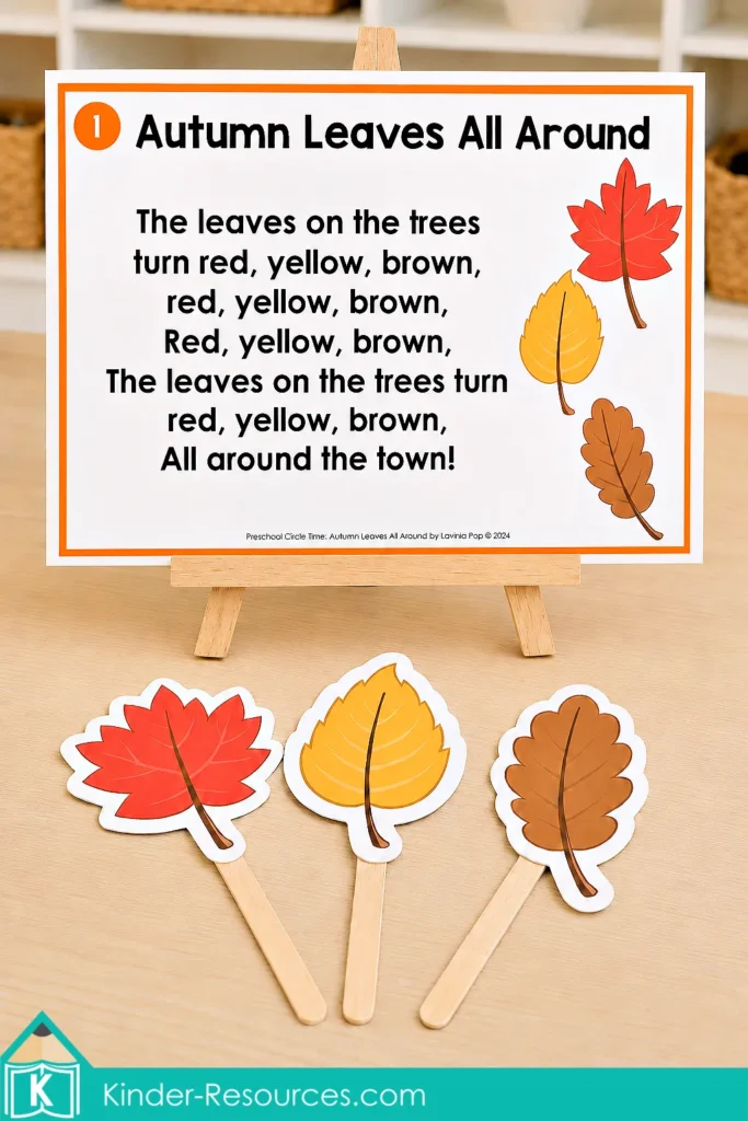 Autumn leaves preschool activities song poster displayed on a wooden easel with red, yellow and brown leaf props attached to craft sticks.